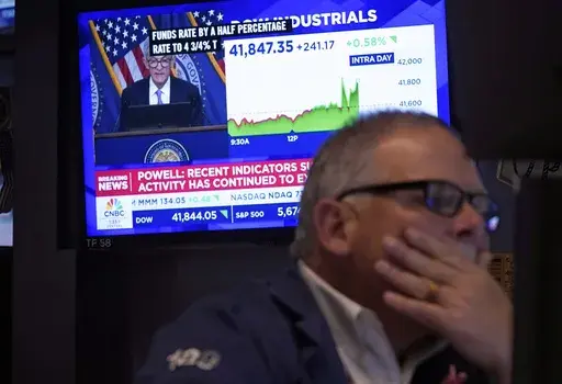 Trader Michale Conlon, right, works on the floor of the New York Stock Exchange as Federal Reserve Chair Jerome Powell's news conference appears on a television screen behind him, Wednesday, Sept. 18, 2024. (AP Photo/Richard Drew)