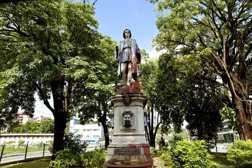 A vandalized statue of Christopher Columbus towers over Columbus Square in Port of Spain, Trinidad and Tobago, Wednesday, Aug. 28, 2024. Officials in the Caribbean island nation are reviewing on whether to remove statues, signs and monuments that reference European colonization. (AP Photo/Robert Taylor)