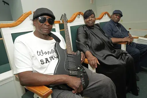 Siblings R.C. Brown, left, Annie Brown Caldwell, center, and Edward Brown, original members of the Staple Jr. Singers, gather for a group photograph in their home church of Johnson Chapel Holiness Church in Aberdeen, Miss., May 20, 2024. (AP Photo/Rogelio V. Solis)