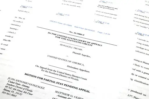 Pages from the Justice Department's motion to the 11th Circuit U.S. Court of Appeals in Atlanta are photographed Friday, Sept. 16, 2022. The Justice Department asked the federal appeals court to lift a judge's order that temporarily barred it from reviewing a batch of classified documents seized during an FBI search of former President Donald Trump's Florida home last month. (AP Photo/Jon Elswick)