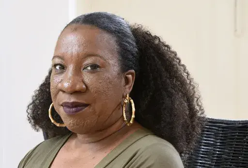 Tarana Burke, founder and leader of the #MeToo movement, sits in her home in Baltimore on Tuesday, Oct. 13, 2020. (AP Photo/Steve Ruark, File)