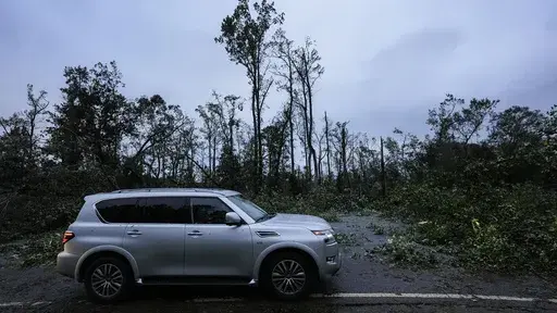 Vehicles move slowly around trees that have fallen after Hurricane Helene moved through the area, Sept. 27, 2024, in Valdosta, Ga. (AP Photo/Mike Stewart, File)
