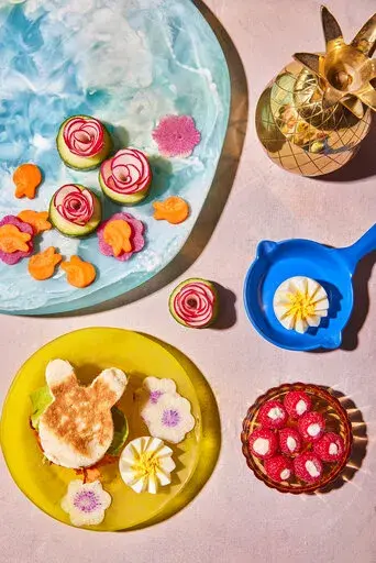 This image released by Harvest shows a breakfast recipe for carrot bacon along with watermelon radish and eggs in the shape of flowers and raspberry parfait bites from the book "Dictator Lunches: Inspired Meals That Will Compel Even the Toughest of Children" by Jenny Mollen. (Lauren Volo/Harvest via AP)