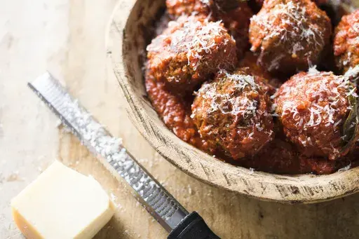 This image released by Milk Street shows a recipe for Neapolitan meatballs with ragu sauce. (Milk Street via AP)