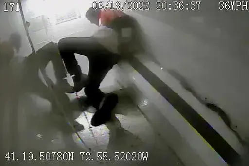 In this image taken from police surveillance video provided by New Haven Police, Richard "Randy" Cox slides down the back of a police van while being transported after being detained by New Haven Police on June 19, 2022, in New Haven, Conn. On Saturday, June 10, 2023, New Haven agreed to a $45 million settlement with Cox, who was paralyzed while being transported handcuffed and without a seat belt in the back of a police van last year. (New Haven Police via AP, File)