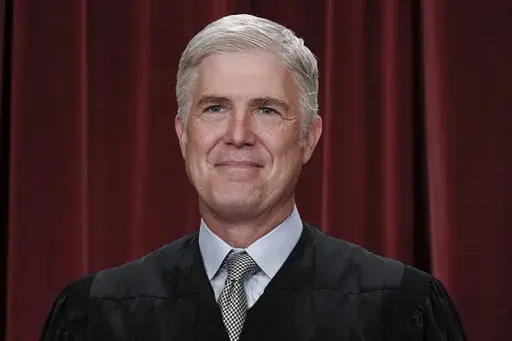Associate Justice Neil Gorsuch joins other members of the Supreme Court as they pose for a new group portrait, at the Supreme Court building in Washington, Friday, Oct. 7, 2022. Gorsuch called emergency measures taken during the COVID-19 crisis that killed more than 1 million Americans perhaps “the greatest intrusions on civil liberties in the peacetime history of this country.” The 55-year-old conservative justice pointed to orders closing schools, restricting church services, mandating vac
