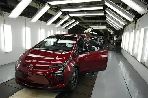 Assembly line worker Janice DeBono looks over a 2023 Chevrolet Bolt EUV at the General Motors Orion Assembly, June 15, 2023, in Lake Orion, Mich. Government tallies show only 11 of the more than 50 EVs on sale in the U.S. are eligible for tax credits so far this year. Still qualifying for credits are the Tesla Model Y SUV, Chevrolet Bolt compact car and Rivian R1T pickup truck. (AP Photo/Carlos Osorio, File)