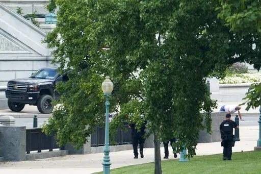 A man is apprehended after being in a pickup truck parked on the sidewalk in front of the Library of Congress' Thomas Jefferson Building, as seen from a window of the U.S. Capitol, Aug. 19, 2021, in Washington. A man who caused evacuations and an hourslong standoff with police on Capitol Hill when he claimed he had a bomb in his pickup truck outside the Library of Congress pleaded guilty on Friday, Jan. 27, 2023, to a charge of threatening to use an explosive. Floyd Ray Roseberry faces up to 10 
