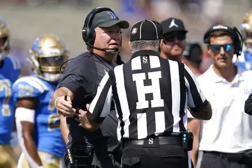 UCLA head coach Chip Kelly talks with an official during the first half of an NCAA college football game against Utah in Pasadena, Calif., Saturday, Oct. 8, 2022. (AP Photo/Ashley Landis)