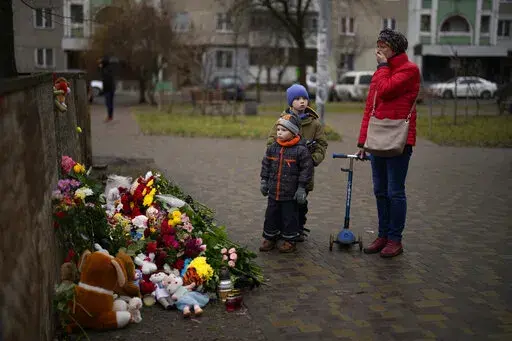 People pay their respects at a makeshift memorial at the scene where a helicopter crashed into civil infrastructure on Wednesday, Jan. 18, in Brovary, on the outskirts of Kyiv, Ukraine, Friday, Jan. 20, 2023. This past week has been an especially tragic one for Ukraine. A barrage of Russian missiles struck an apartment complex in the southeastern city of Dnipro on Jan. 14, and the death toll from that attack rose steadily in the days that followed, with at least 45 civilians killed, including si