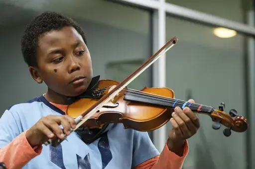 Johnathan Nealy plays the violin as part of a string music program at New Hope Presbyterian Church on Wednesday, Oct. 16, 2024, in Anaheim, Calif. (AP Photo/William Liang)