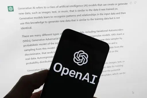 The OpenAI logo is seen on a mobile phone in front of a computer screen displaying output from ChatGPT, on March 21, 2023, in Boston. European lawmakers have rushed to add language on general artificial intelligence systems like ChatGPT as they put the finishing touches on the Western world's first AI rules. (AP Photo/Michael Dwyer, File)