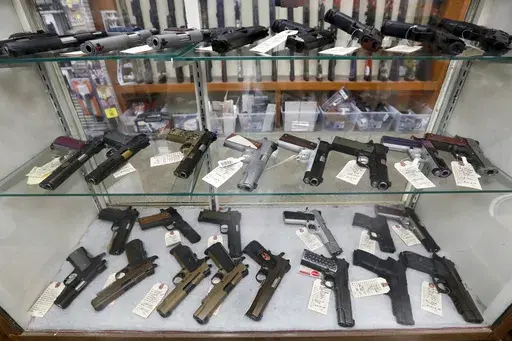 Semi-automatic handguns are displayed at shop in New Castle, Pa., March 25, 2020. A federal appeals court has dealt a legal setback to the Biden administration on guns in a lawsuit challenging tighter regulations on stabilizing braces, an accessory used in several mass shootings. The Fifth Circuit Court of Appeals temporarily blocked an administration rule from going into effect for the gun owners and groups who filed the lawsuit. The order came shortly before a deadline for people to register t