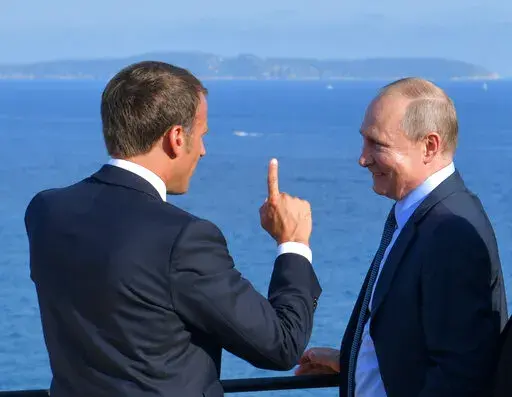 French President Emmanuel Macron, left, talks with Russian President Vladimir Putin during their meeting at the fort of Bregancon in Bormes-les-Mimosas, southern France, Monday Aug. 19, 2019. (Alexei Druzhinin, Sputnik, Kremlin Pool Photo via AP, File)