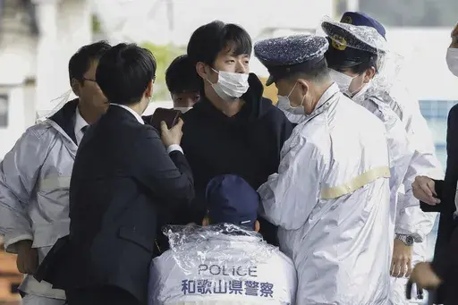 A man who was later identified as Ryuji Kimura is arrested after what appeared to be a pipe bomb was thrown at Japanese Prime Minister Fumio Kishida during his visit at a port in Wakayama, western Japan, on April 15, 2023. Prosecutors in Japan indicted the 24-year-old man Wednesday, Sept. 6, 2023 on attempted murder and other charges in the explosive attack on Prime Minister Fumio Kishida in April, Japanese media reported. (Kyodo News via AP, File)
