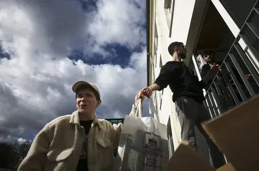 From left, Danya, 21, Gabriel, 21 and Borden, 17 all refugees from Odesa, Ukraine help to deliver bags with food to needy people during preparations for the celebration of Jewish Passover at the Chabad Jewish Education Center in Berlin, Germany, Thursday, April 7, 2022. Rabbis and Jewish organizations are working round the clock within Ukraine, Eastern Europe and other parts of Europe to make sure that Jews who remain in Ukraine and refugees who have fled as far away as Israel are able to celebr