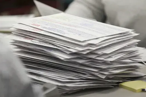 A stack of absentee ballots wait to be processed by the Lee County Resolution Board at the Circuit Clerks Office in the Lee County Justice Center in Tupelo, Miss., on Nov. 3, 2020. Mississippi Gov. Tate Reeves signed a bill Wednesday, March 22, 2023, that will set new restrictions on who can gather other people's absentee ballots. The bill will become law on July 1. (Thomas Wells/Northeast Mississippi Daily Journal via AP, File)