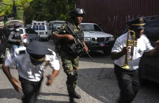 Police escort musicians arriving for the swearing-in ceremony of a transitional council tasked with selecting a new prime minister and cabinet at the Prime Minister's office in Port-au-Prince, Haiti, Thursday, April 25, 2024. (AP Photo/Ramon Espinosa)
