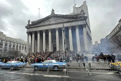 Throngs of actors portraying protesters, some in make-up, gather outside a courthouse for the filming of a scene in the "Joker" movie sequel in New York, Saturday, March 25, 2023. Production crews had to wrestle with the possibility that filming could be disrupted by real-life protests over the Trump case, none of which have materialized so far. (AP Photo/Bobby Caina Calvan)