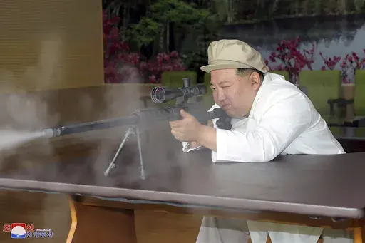 In this undated photo provided by the North Korean government, North Korean leader Kim Jong Un tries a weapon during his three-day inspection from Aug. 3 until Aug. 5, 2023 at major munitions factories in North Korea. Independent journalists were not given access to cover the event depicted in this image distributed by the North Korean government. The content of this image is as provided and cannot be independently verified. Korean language watermark on image as provided by source reads: "KCNA" 