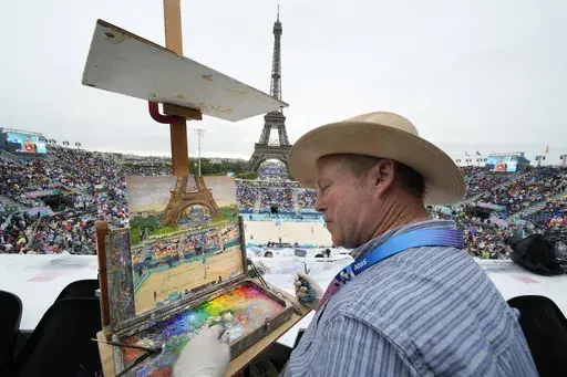 Peter Spens, of London, England, paints the scene at Eiffel Tower Stadium during a beach volleyball match at the 2024 Summer Olympics, Saturday, July 27, 2024, in Paris, France. (AP Photo/Robert F. Bukaty)