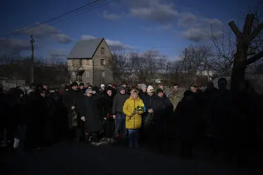 People pay respect as the coffin containing the body of Serhii Havryliuk, 48, passes by during his funeral procession in Tarasivka village, near Kyiv, Ukraine, Wednesday, Feb. 15, 2023. Serhii Havryliuk, an officer of the Azov Assault Brigade, died while defending the Azovstal steel plant in Mariupol on April 12, 2022 against the Russians. Serhii has finally been buried after DNA tests confirmed his identity. (AP Photo/Emilio Morenatti, File)
