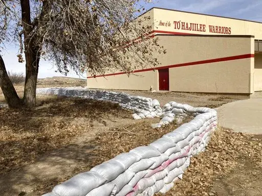This Feb. 17, 2023 image shows a wall of sandbags protecting the school in the Navajo community of To'Hajiilee, New Mexico. To'Hajiilee Community School is just one of dozens funded by the U.S. Bureau of Indian Education that are in desperate need of repair or replacement. The agency estimates it would cost roughly $6.2 billion to address the needs of those schools in poor condition. (AP Photo/Susan Montoya Bryan)