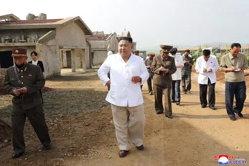 In this undated photo provided on July 23, 2020 by the North Korean government, North Korean leader Kim Jong Un, center, visits a new chicken farm being built in Hwangju County, North Korea. Independent journalists were not given access to cover the event depicted in this image distributed by the North Korean government. The content of this image is as provided and cannot be independently verified. Korean language watermark on image as provided by source reads: "KCNA" which is the abbreviation f