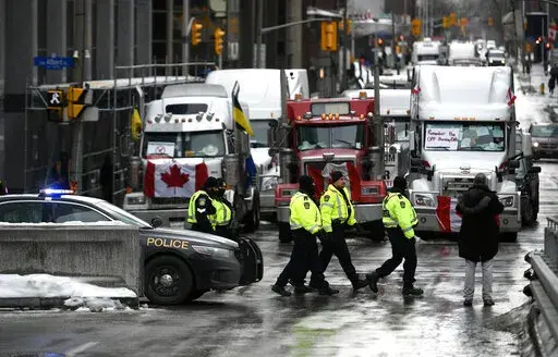 Police officers patrol on foot along Albert Street as a protest against COVID-19 restrictions continue in Ottawa, Thursday, Feb. 10, 2022. On Friday, Feb. 11, 2022, The Associated Press reported on stories circulating online incorrectly claiming half of the police officers in Canada’s capital city resigned on Monday in support of protests against vaccine requirements. (Justin Tang /The Canadian Press via AP, File)