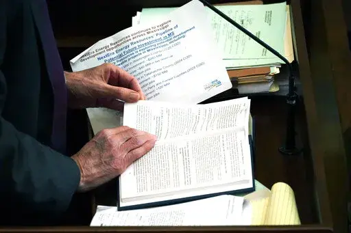 State Rep. Tommy Reynolds, D-Charleston, refers to a section of Mississippi Code, Tuesday, Feb. 21, 2023, as he speaks on a bill at the Mississippi Capitol in Jackson, Miss.. Lawmakers are working towards a Wednesday deadline for original floor action on appropriations and revenue bills originating in their own House. (AP Photo/Rogelio V. Solis)