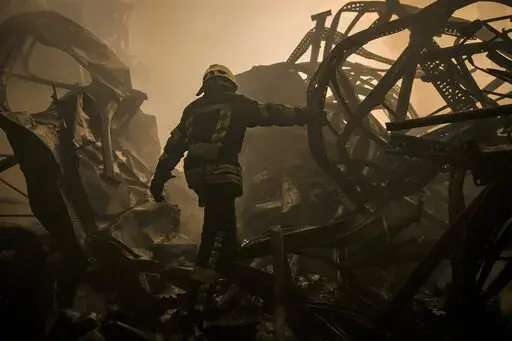 A Ukrainian firefighter walks inside a large food products storage facility which was destroyed by an airstrike in the early morning hours on the outskirts of Kyiv, Ukraine, Sunday, March 13, 2022. Waves of Russian missiles pounded a military training base close to Ukraine's western border with NATO member Poland, killing 35 people, following Russian threats to target foreign weapon shipments that are helping Ukrainian fighters defend their country against Russia's grinding invasion.(AP Photo/Va