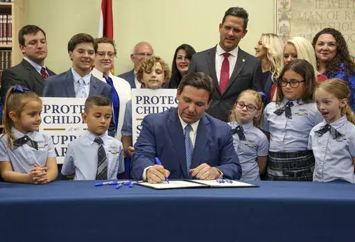 Florida Gov. Ron DeSantis signs the Parental Rights in Education bill, also known as the "Don't Say Gay" bill, at Classical Preparatory School, March 28, 2022, in Shady Hills, Fla. Students and teachers will be able to speak freely about sexual orientation and gender identity in Florida classrooms, provided it’s not part of instruction, under a settlement reached Monday, March 11, 2024, between Florida education officials and civil rights attorneys who had challenged a state law which critics 
