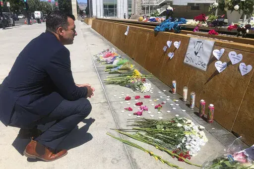 San Jose Mayor Sam Liccardo stops to view a makeshift memorial for the rail yard shooting victims in front of City Hall in San Jose, Calif., on May 27, 2021. Gun owners would be required to carry liability insurance and pay a fee under a proposed ordinance in the city of San Jose that officials say would be the first of its kind in the United States. Mayor Liccardo says it would also encourage the 5,500 households with a legally registered gun to have gun safes, trigger locks, and to take gun sa