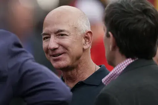 Amazon founder Jeff Bezos is seen on the sidelines before the start of an NFL football game, Sept. 15, 2022, in Kansas City, Mo. The founder of Amazon is buying a home on an exclusive barrier island in Miami where he'll be neighbors with Tom Brady, Ivanka Trump and her husband, Jared Kushner. (AP Photo/Charlie Riedel, File)