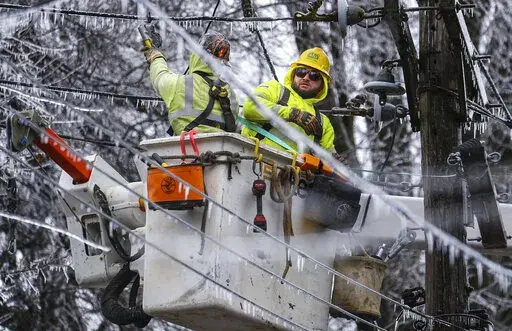 Crews work to restore power to the Central Garden neighborhood of Memphis, Tenn., on Friday, Feb. 4, 2022. More than 120,000 customers were without power Friday afternoon in Shelby County, according to poweroutage.us, which tracks utility reports.  (Patrick Lantrip/Daily Memphian via AP)