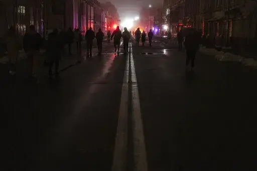 People walk at the city center which lost electrical power after yesterday's Russian rocket attack in Kyiv, Ukraine, Thursday, Nov. 24, 2022. (AP Photo/Evgeniy Maloletka)