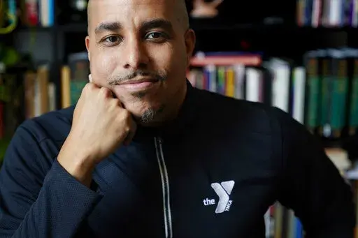 Rico X poses at his home March 14, 2022, in Hermitage, Tenn. X, who oversees the before- and afterschool programs run by the YMCA of Middle Tennessee, says enrollment has had to be capped as parents return to work after the COVID pandemic because of staff shortages, leaving capacity at about 70% of what it was before the pandemic. (AP Photo/Mark Humphrey)