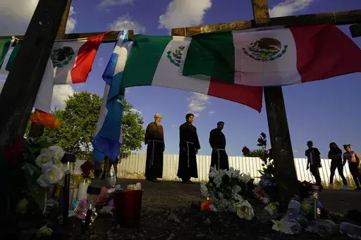 People visit a makeshift memorial honoring the victims and survivors of a human smuggling tragedy, where dozens of migrants were found in an airless tractor-trailer rig, in San Antonio, July 6, 2022. (AP Photo/Eric Gay, File)