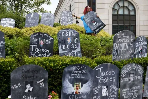Jayde Newton helps to set up cardboard gravestones with the names of victims of opioid abuse outside the courthouse where the Purdue Pharma bankruptcy is taking place in White Plains, N.Y., on Aug. 9, 2021. A three-judge panel of the 2nd U.S. Circuit Court of Appeals in New York on Tuesday, May 30 overturned a lower court’s 2021 ruling that found bankruptcy courts did not have the authority to protect members of the Sackler family who own the company and who have not filed for bankruptcy prote