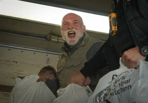 Jose Andres, a Spanish chef, and founder of World Central Kitchen unloads the humanitarian food packages delivered with WCK's truck in Kherson, Ukraine, on Nov. 15, 2022. World Central Kitchen, called a halt to its work in the Gaza Strip after an apparent Israeli strike killed seven of its workers, mostly foreigners. (AP Photo/Efrem Lukatsky, File)