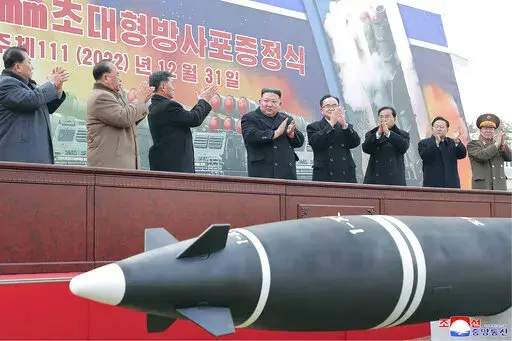 In this photo provided by the North Korean government, North Korean leader Kim Jong Un, center, attends a ceremony of donating 600mm super-large multiple launch rocket system at a garden of the Workers' Party of Korea headquarters in Pyongyang, North Korea Saturday, Dec. 31, 2022. Independent journalists were not given access to cover the event depicted in this image distributed by the North Korean government. The content of this image is as provided and cannot be independently verified. Korean 