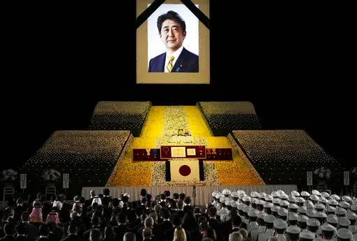A portrait of former Japanese Prime Minister Shinzo Abe hangs on the stage during his state funeral, Tuesday, Sept. 27, 2022, Tokyo. Abe was assassinated in July. (Franck Robichon/Pool Photo via AP)