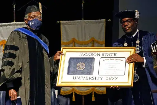 FILE _ Jackson State University Thomas K. Hudson, right, presidents an honorary degree to JSU president emeritus John A Peoples Jr. on Oct. 28, 2021, in Jackson, Miss. The board that governs Mississippi's eight public universities put Hudson on paid administrative leave on Thursday, March 2, 2023, and named Elaine Hayes-Anthony as temporary acting president. (AP Photo/Rogelio V. Solis, File