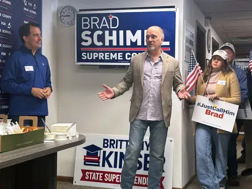 Wisconsin Supreme Court candidate Brad Schimel, center, speaks with supporters as former Gov. Scott Walker, left, watches on Monday, March 31, 2025, in Madison, Wis. (AP Photo/Scott Bauer)