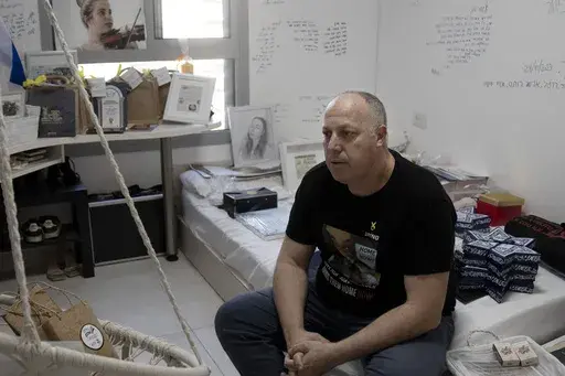 Shlomi Berger sits in his daughter's bedroom in Holon, Israel, Wednesday, April 17, 2024. Agam, 19, was abducted two days after the start of her army service along the border with Gaza during a cross-border attack by Hamas on Oct. 7, 2023. "The Passover story says we come from slaves to free people, so this is a parallel story," Berger said. "This is the only thing I believe that will happen. That Agam will get out from darkness to light. She and all of the other hostages." (AP Photo/Maya Alleru