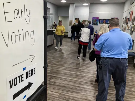 People wait in line to early vote for the U.S. Senate runoff election in Georgia between Sen. Raphael Warnock and challenger Herschel Walker, on Nov. 28, 2022, in Kennesaw, Ga., near Atlanta. After years of criticizing mail voting and trying to ban so-called "ballot harvesting," Republicans are reversing course. They are poised to launch aggressive get-out-the-vote campaigns for 2024 that employ just those strategies.(AP Photo/Mike Stewart, File)