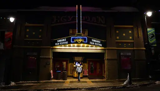 A pedestrian peers into the ticket booth of the Egyptian Theatre before the start of the 2023 Sundance Film Festival, Wednesday, Jan. 18, 2023, in Park City, Utah. The annual independent film festival runs from Jan. 19-29. (AP Photo/Chris Pizzello)