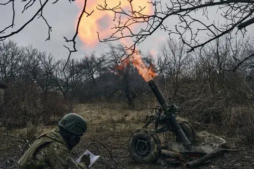Volunteer soldiers fire towards Russian positions close to Bakhmut, Donetsk region, Ukraine, Wednesday, March 8, 2023. (AP Photo/Libkos)