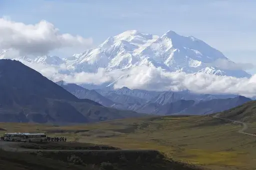 Sightseeing buses and tourists are seen at a pullout popular for taking in views of North America's tallest peak, Denali, in Denali National Park and Preserve, Alaska, Aug. 26, 2016. A Malaysian climber who died near the top of North America's tallest mountain while sheltering in a snow cave was identified by park officials Saturday, June 1, 2024. (AP Photo/Becky Bohrer, File)