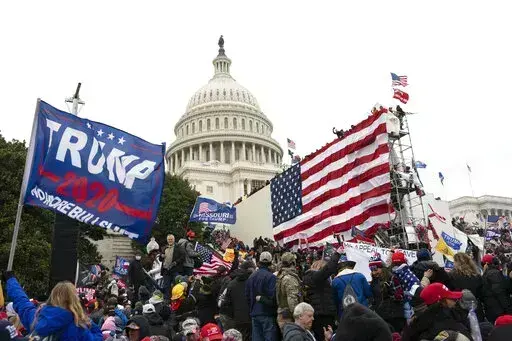 Violent insurrectionists loyal to President Donald Trump stand outside the U.S. Capitol in Washington on Jan. 6, 2021. The public hearings of the House committee investigating the insurrection pose a challenge to Democrats seeking to maintain narrow control of Congress. (AP Photo/Jose Luis Magana, File)